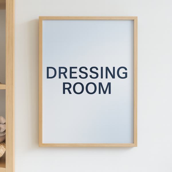 Framed print displaying the text 'DRESSING ROOM' in bold black letters on a light background.