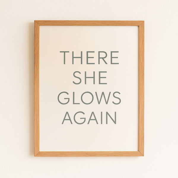 Framed wall art print with the text 'There She Glows Again' in a simple, modern font on a light background.